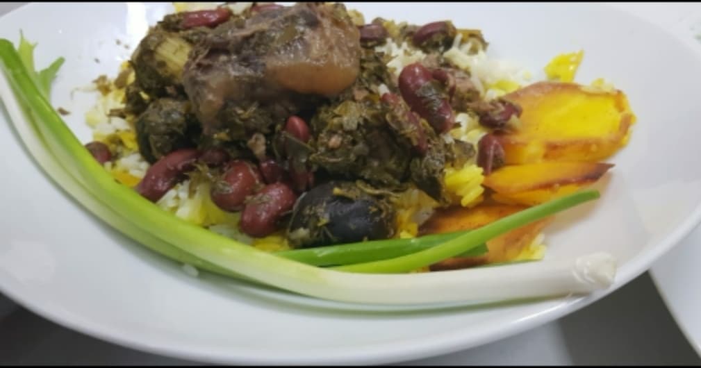 Khoresht Sabzi — a green herb-and-bean braise served over saffron rice