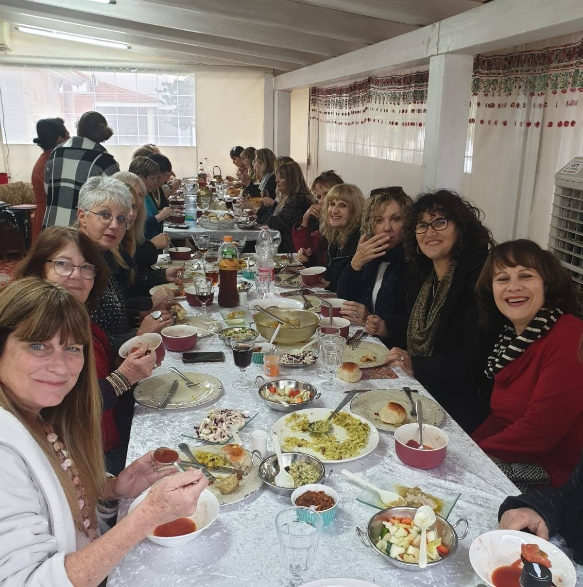 A spread of Persian-Jewish salads and mezze on an embroidered orange runner